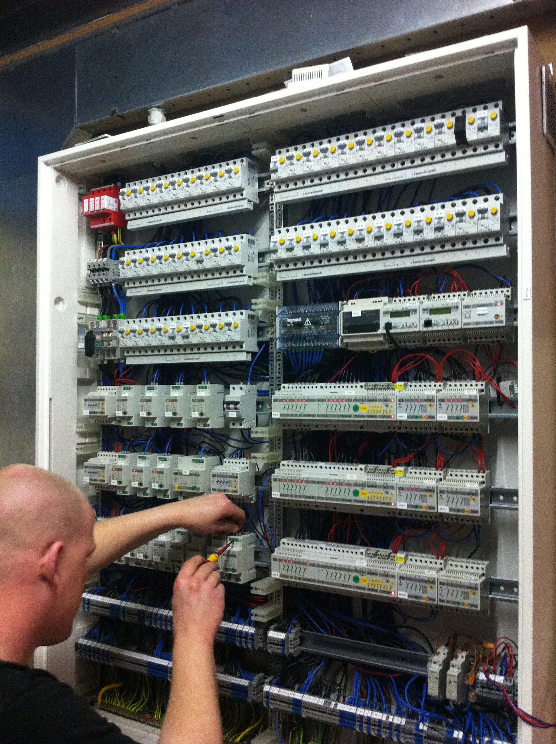 Monteur van Tino Elektrotechniek bedraadt een verdeelkast